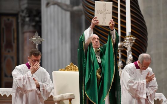 Pope Francis holds up the Lectionary (or book of Mass readings) that was used during the Second Vatican Council, Jan. 26, 2020,  in St. Peter's Basilica, the first Sunday of the Word of God, encouraging Catholics to read the Bible. (CNS/Vatican Media)