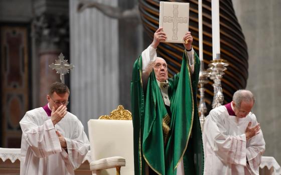 Pope Francis holds up the Lectionary (or book of Mass readings) that was used during the Second Vatican Council, Jan. 26, 2020,  in St. Peter's Basilica, the first Sunday of the Word of God, encouraging Catholics to read the Bible. (CNS/Vatican Media)