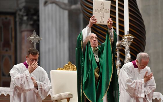 Pope Francis holds up the Lectionary, or book of Mass readings, that was used during the Second Vatican Council. (CNS/Vatican Media)