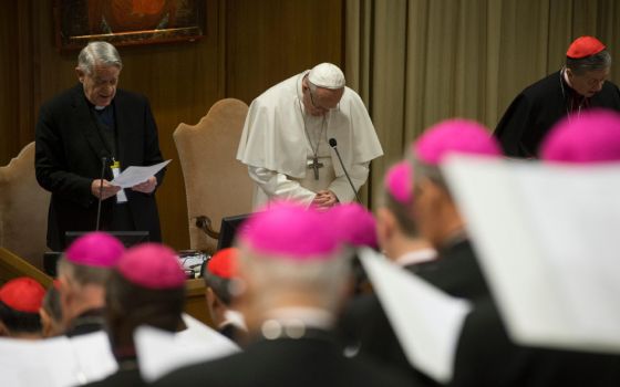 Pope Francis prays during the February 2019 Vatican meeting on the protection of minors. On the left is Jesuit Fr. Federico Lombardi. On the right is Chicago Cardinal Blase Cupich. (CNS/Reuters/Vatican Media)