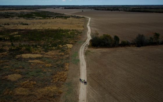A group of migrants walk past plowed farmland near Penitas, Texas, Jan. 10, 2019. (CNS/Reuters/Adrees Latif)
