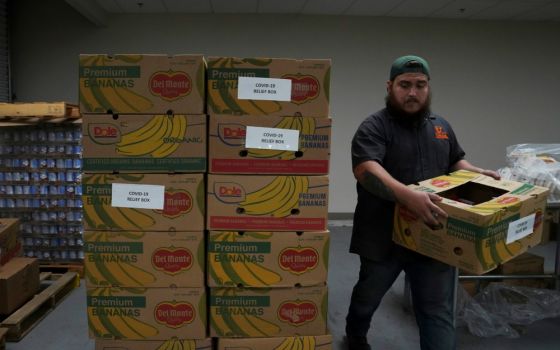 A man in Laredo, Texas, stacks relief boxes at the South Texas Food Bank March 20 during the coronavirus outbreak. (CNS/Reuters/Veronica G. Cardenas)