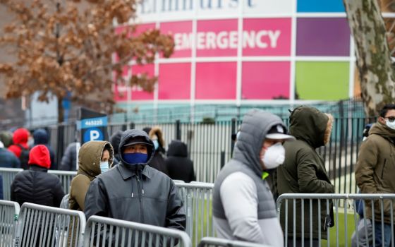 People wearing protective gear wait in line to be tested for the coronavirus (COVID-19) outside Elmhurst Hospital Center in the Queens borough of New York City March 25. (CNS/Reuters/Stefan Jeremiah)