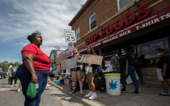 A woman in Minneapolis expresses her anger and frustration May 28 at the site where George Floyd was pinned down May 25 by a police officer. Floyd later died at a local hospital. (CNS/The Catholic Spirit/Dave Hrbacek)