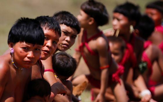 Young Yanomami look on as members of a medical team with the Brazilian army examine members of the Indigenous tribe in the state of Roraima July 1, 2020, during the COVID-19 pandemic. (CNS/Reuters/Adriano Machado)