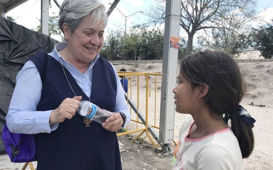 Sr. Norma Pimentel, director of Catholic Charities of the Rio Grande Valley in Texas, speaks with a young resident of a tent camp housing some 2,500 asylum-seekers in Matamoros, Mexico, Feb. 29, 2020. (CNS/David Agren)