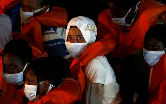 Rescued migrants look out from an Armed Forces of Malta vessel upon their arrival in Valletta, Malta, Aug. 3, 2020.