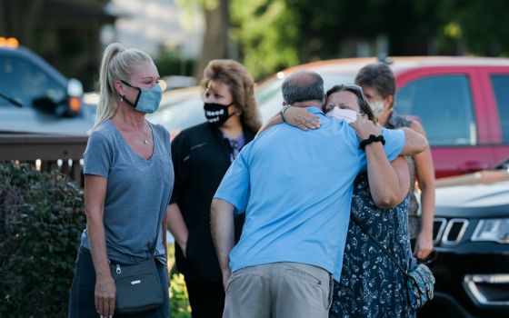 People attend a prayer vigil outside St. Joseph Catholic Church in Trenton, Michigan, Aug. 17, for Robert Chiles, a parishioner, and Fr. Stephen Rooney, St. Joseph's pastor, who disappeared in a boating accident on the Detroit River the previous day.