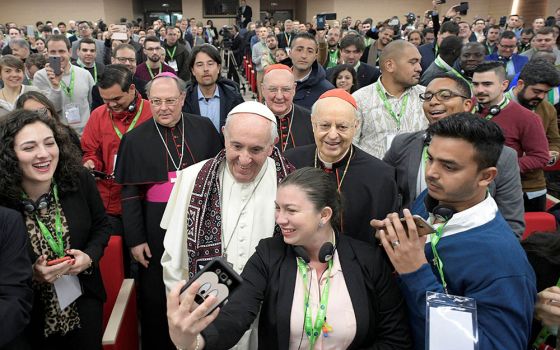 Pope Francis poses for a selfie during a gathering of youth delegates at the Pontifical International Maria Mater Ecclesiae College in Rome, ahead of the Synod of Bishops on young people in 2018. (CNS/Vatican Media)