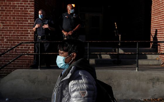 A woman walks past police officers in the Brooklyn borough of New York City Oct. 14, 2020. (CNS/Reuters/Shannon Stapleton)