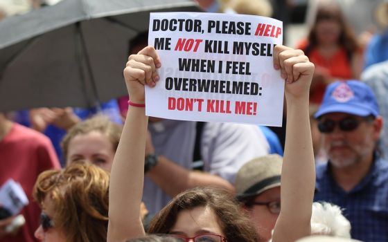 A woman is pictured in a file photo holding up a sign during a rally against assisted suicide on Parliament Hill in Ottawa, Ontario. (CNS/Art Babych)