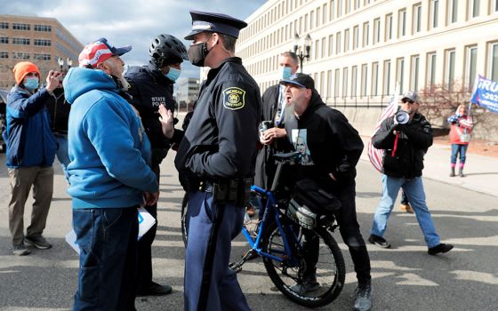 Michigan State Police in Lansing separate supporters of President Donald Trump and a supporter of President-elect Joe Biden Nov. 23 as the Board of State Canvassers met to certify the results of the election. (CNS/Reuters/Rebecca Cook)