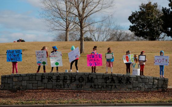 Girl Scouts in Atlanta hold signs urging residents to vote in the runoff election for both of Georgia's U.S. Senate seats Jan. 3. (CNS/Reuters/Brian Snyder)