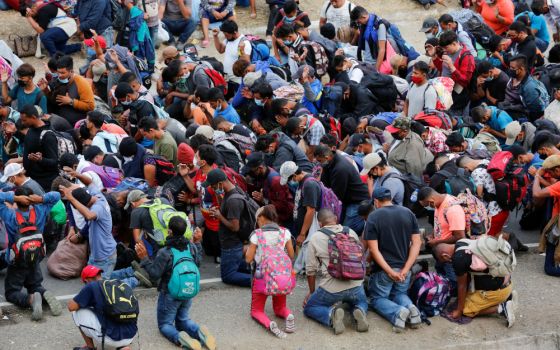 A caravan of mainly Honduran migrants heading to the United States kneel in prayer Jan. 17 in Vado Hondo, Guatemala. (CNS/Reuters/Luis Echeverria)