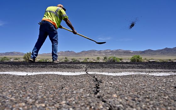 A Nevada Department of Transportation worker repairs damage to Highway 95 near Tonopah, Nevada, May 15, 2020. President Joe Biden's American Jobs Plan calls for investing more than $2 trillion over the next decade in upgrading the nation's roads, bridges,