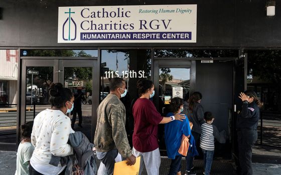 Migrants seeking asylum in the U.S. walk into a temporary humanitarian respite center run by Catholic Charities of the Rio Grande Valley in McAllen, Texas, April 8. (CNS/Reuters/Go Nakamura)