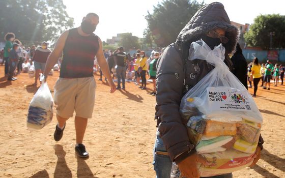 People in need receive food aid in São Paulo April 14 during the COVID-19 pandemic. (CNS/Reuters/Carla Carniel)