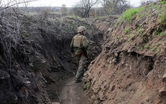 A service member of the Ukrainian armed forces walks at fighting positions on the line of separation near the rebel-controlled city of Donetsk April 26. (CNS/Reuters/Anastasia Vlasova)