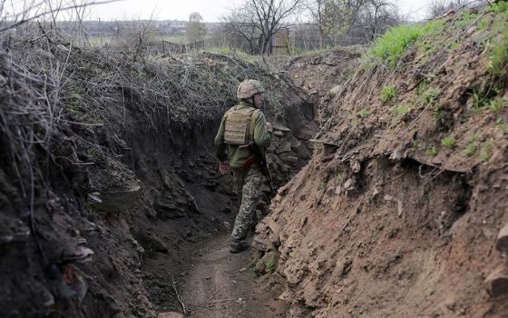 A service member of the Ukrainian armed forces walks at fighting positions on the line of separation near the rebel-controlled city of Donetsk April 26. (CNS/Reuters/Anastasia Vlasova)