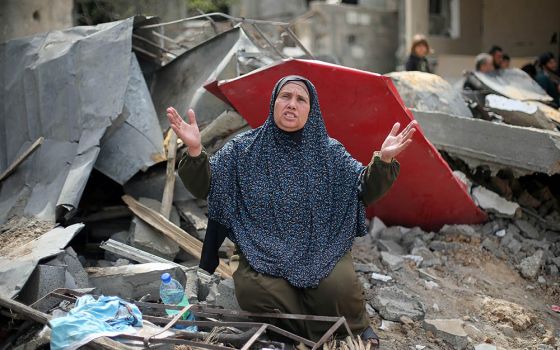 A Palestinian woman reacts after returning to her destroyed house in Gaza May 21, following the Israel-Hamas truce. The May 21 truce followed more than a week of fighting that claimed hundreds of lives. (CNS/Reuters/Ibraheem Abu Mustafa)