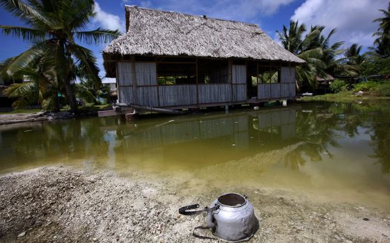 An abandoned house that is affected by seawater during high tides stands next to a small lagoon near the village of Tangintebu on South Tarawa in the central Pacific island nation of Kiribati May 25, 2013. Pope Francis said island nations need protection 
