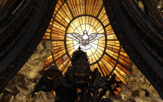 The Holy Spirit window is seen through the baldacchino in St. Peter's Basilica at the Vatican. (CNS/Paul Haring)