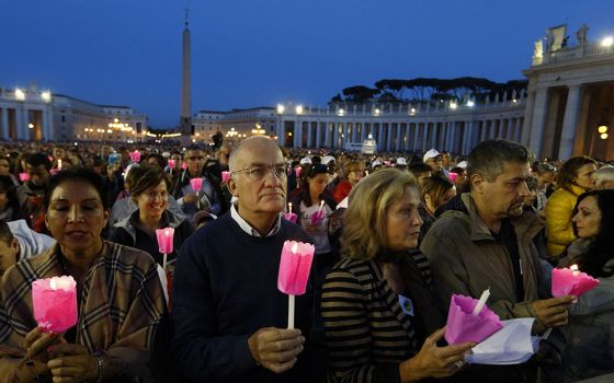 People hold candles during a prayer vigil for the Synod of Bishops on the family attended by Pope Francis in St. Peter's Square at the Vatican Oct. 3, 2015.