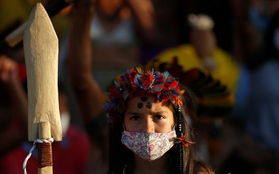 A young Indigenous person takes part in a protest for land demarcation and against Brazilian President Jair Bolsonaro's government, outside the supreme court in Brasília June 18, 2021. (CNS/Reuters/Adriano Machado)