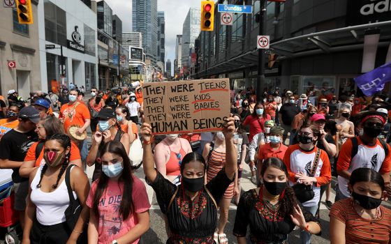 People take part in a march on Canada Day in Toronto July 1, after the discovery of hundreds of unmarked graves on the grounds of former residential schools for Indigenous children in Canada. (CNS/Reuters/Carlos Osorio)