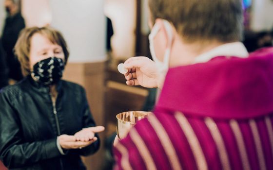 A woman receives Communion at St. John the Baptist Church in Monroe, Michigan, amid the coronavirus pandemic. (CNS/Courtesy of Detroit Catholic)
