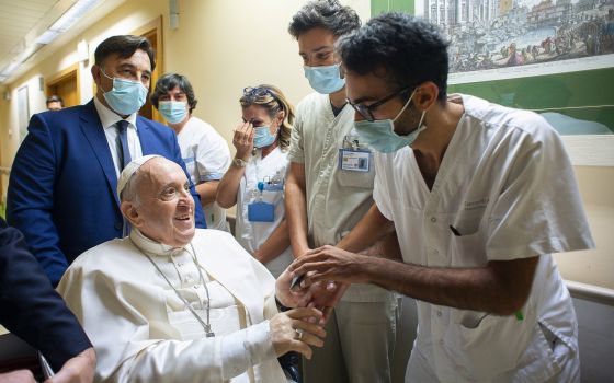 Pope Francis gives a rosary to a member of the medical staff at Gemelli hospital in Rome July 11, 2021, as he recovers following scheduled colon surgery. The pope expressed his gratitude for "making me feel at home" while he recovered from surgery, in a J