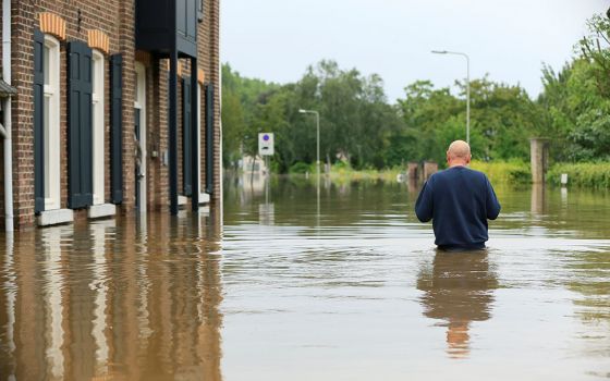 A person wades through floodwaters in Guelle, Netherlands, July 16. A record rainfall caused dams to burst and rivers to overflow into towns and streets across western Germany, Belgium, as well as parts of the Netherlands, Switzerland and northern France.