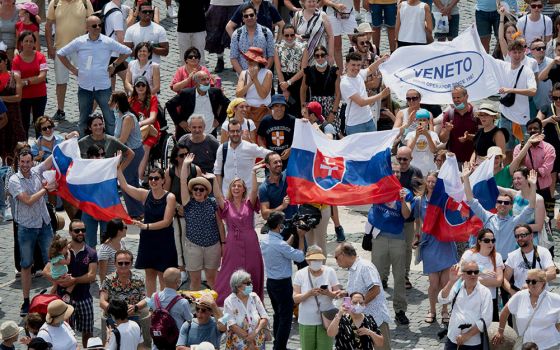 Pilgrims holding the Slovak flag cheer in St. Peter's Square at the Vatican July 4, 2021, as Pope Francis announces he will visit their country Sept. 12-15. (CNS/Vatican Media)