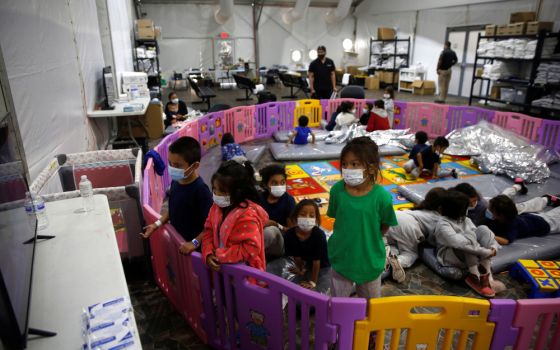 Young unaccompanied migrants, ages 3 to 9, watch television inside a playpen March 30 at the holding facility in Donna, Texas. (CNS/pool via Reuters/Dario Lopez-Mills)