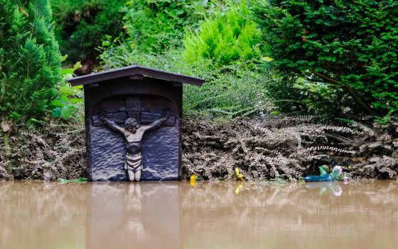 A grave marker is surrounded by floodwaters at a cemetery in Erftstadt, Germany, July 16, 2021. Aid agencies in developing countries more accustomed to dealing with natural disasters have offered words of compassion and concern in response to Germany's di