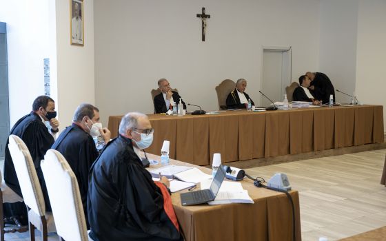 The judges of the Vatican City State criminal court -- Venerando Marano, Giuseppe Pignatone and Carlo Bonzano -- sit under a crucifix in a makeshift Vatican courtroom July 27, 2021, as the trial of 10 defendants in a financial malfeasance case begins. (CN