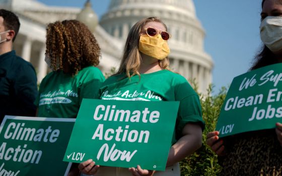 People hold League of Conservation Voters signs during a news conference urging action on climate change outside the U.S. Capitol in Washington July 28, 2021. (CNS photo/Elizabeth Frantz, Reuters)