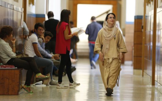 A member of a religious congregation walks down the hall as lay students wait between classes at the Pontifical Lateran University in Rome in this Sept. 20, 2013, file photo. The Vatican's Congregation for Catholic Education has released guidelines on the