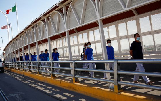 Migrants expelled from the U.S. and sent back to Mexico under Title 42 walk toward Mexico at the Paso del Norte International border bridge, in this picture taken from Ciudad Juarez, Mexico, July 29, 2021. (CNS photo/Jose Luis Gonzalez, Reuters)