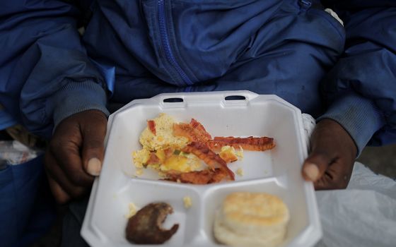 A homeless person in Birmingham, Alabama, eats breakfast during the distribution of food and clothes April 18, 2020. (CNS/Reuters/Carlos Barria)