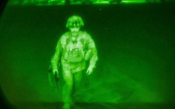 U.S. Army Maj. Gen. Chris Donahue, commander of the 82nd Airborne Division, steps on board a transport plane as the last U.S. service member to leave Kabul, Afghanistan, Aug. 30, in a photo taken via night vision optics. (CNS/XVIII Airborne Corps/Reuters)