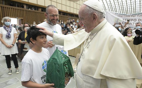 Pope Francis accepts the gift of a handmade "Abraham's tent" from a boy during his general audience in the Paul VI hall at the Vatican Sept. 1, 2021. The gift was given by members of the Laudato Si' Movement. (CNS/Vatican Media)