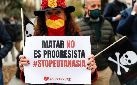 A woman protests against a law to legalize euthanasia as the Spanish Parliament votes to approve it in Madrid March 18, 2021. Her sign reads "Killing is not progressive, stop euthanasia." Increasing calls to legalize euthanasia in several European countri