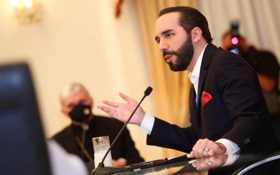 A prelate wearing a protective mask looks on as Salvadoran President Nayib Bukele takes part in a meeting at the Presidential House in San Salvador May 3, 2021. Without naming the president, the bishops said Sept. 12 that making changes without following 