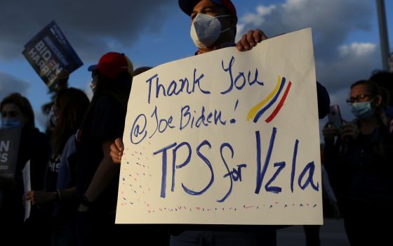 A man in Doral, Fla., holds a sign March 9, 2021, as members of the Venezuelan community react after the Biden administration said it would grant Temporary Protected Status to Venezuelan immigrants living in the United States. (CNS photo/Marco Bello, Reut