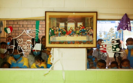 Migrants who were returned to Mexico under Title 42, a public health code provision, after seeking asylum in the U.S. observe a quinceañera celebration through a window at the Casa del Migrante shelter in Ciudad Juarez, Mexico, Sept. 30, 2021. (CNS photo/