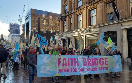 A group of interfaith climate pilgrims join hundreds of people processing into central Glasgow, Scotland, Oct. 30, ahead of the start COP26, the United Nations climate change conference. (EarthBeat photo/Brian Roewe)