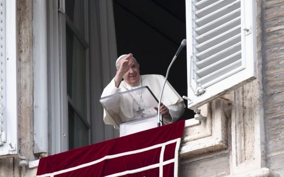 Pope Francis greets people as he leads the Angelus from the window of his studio overlooking St. Peter's Square at the Vatican Oct. 31, 2021. (CNS photo/Vatican Media)