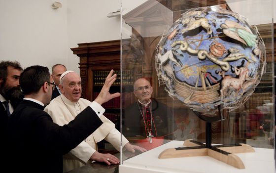 Pope Francis looks at a globe as he inaugurates a new permanent exhibition space in the Vatican Library Nov. 5, 2021. (CNS/Vatican Media)