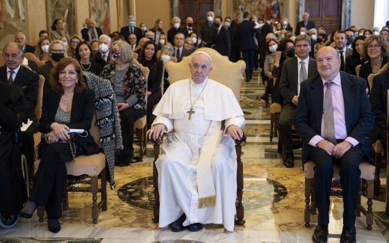Pope Francis is seated next to Valentina Alazrak of Televisa and Philip Pullella of Reuters during a ceremony to honor the two journalists in the Apostolic Palace at the Vatican Oct. 13, 2021. (CNS photo/Vatican Media)